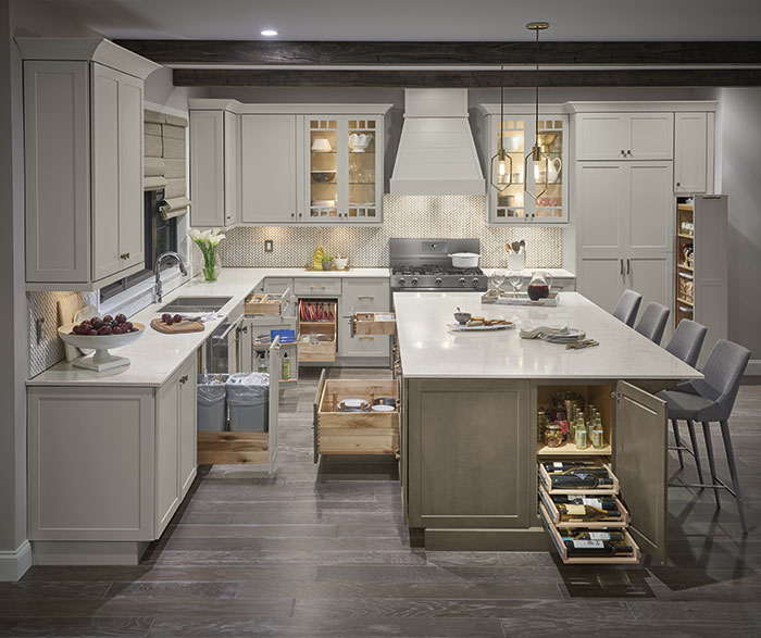 white painted and light stained kitchen cabinets opened to show variety of storage and organization options